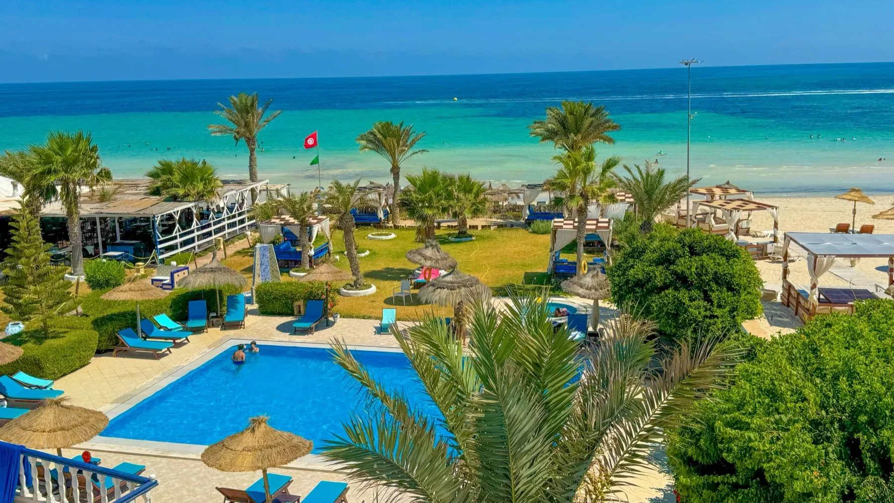 La piscine et les jardins de Dar El Bhar face à la plage de Sidi Mehrez et à la Méditerranée turquoise, à Mezraia, Djerba