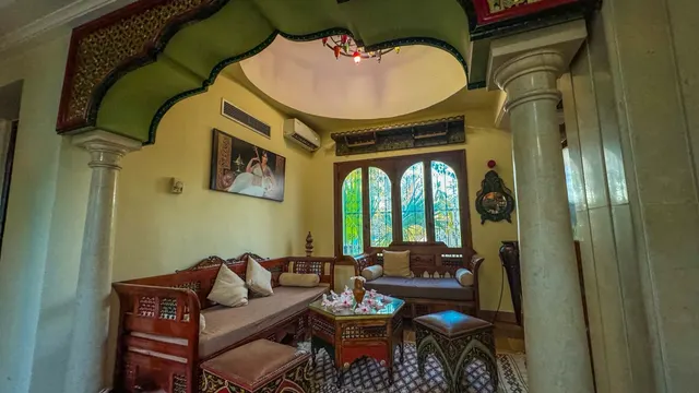 Suite sous coupole de Dar El Bhar : coin salon sous une voûte traditionnelle djerbienne, colonnes et fenêtres en arc